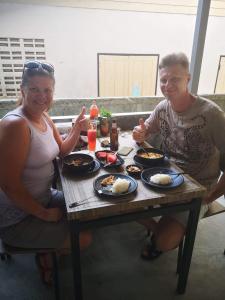 a man and a woman sitting at a table with food at Mateoasis in Ko Kood
