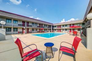 a courtyard with chairs and a pool in a building at Red Roof Inn Lewisville in Lewisville