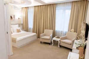 モスクワにあるInvite Hotel Kolomenskayaのベッド1台と椅子2脚が備わるホテルルームです。