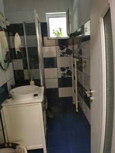 ein kleines Badezimmer mit Waschbecken und Spiegel in der Unterkunft Chic Apartment in Brăila + 33 Fotos
