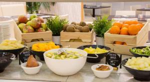 a display of fruits and vegetables in bowls on a table at Holiday Inn Bologna - Fiera by IHG in Bologna