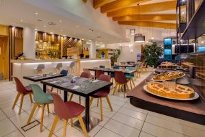 a restaurant with tables and chairs and a buffet at Holiday Inn Bologna - Fiera by IHG in Bologna