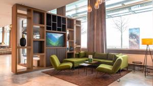 a living room with a green couch and chairs at Holiday Inn Berlin Airport - Conference Centre by IHG in Schönefeld