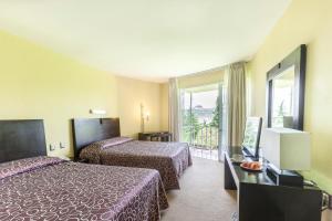 a hotel room with two beds and a window at Hotel Parador Zacatecas in Zacatecas