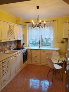 eine Küche mit weißen Schränken und einem Tisch und Stühlen in der Unterkunft Chic Apartment in Brăila