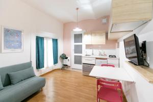 Saragozza Apartments في بولونيا: غرفة معيشة مع أريكة وطاولة ومطبخ