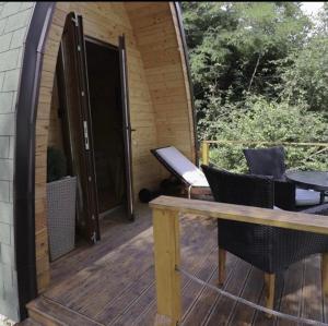 Glamping Jezero في تشاتشاك: سطح خشبي مع طاولة وكراسي