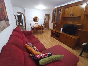 een woonkamer met een rode bank met kussens bij Noelia La Garita Beach y disfruta de tus vacaciones in La Garita