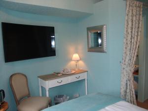 a bedroom with a bed and a desk and a television at Osborne House B&B Workington in Workington