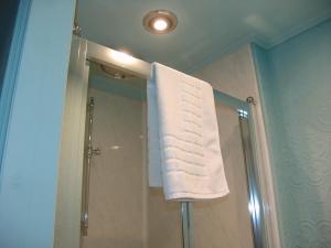 a towel hanging over a shower in a bathroom at Osborne House B&B Workington in Workington