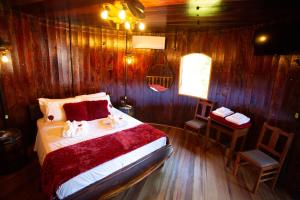 a bedroom with a bed and a wooden wall at Pousada Botte di Vino in Garibaldi