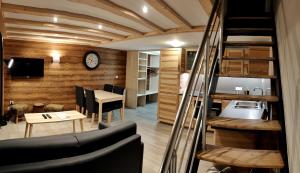 a living room with a staircase and a room with a table at Chez Carole et Arnaud in Val Thorens