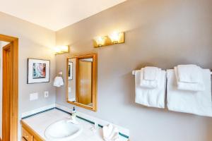 a bathroom with a sink and a mirror and towels at Seaside Serenade in Seaside +28 photos