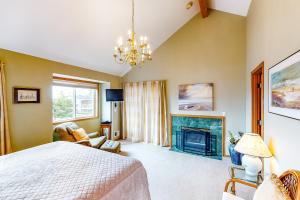a bedroom with a bed and a fireplace at Seaside Serenade in Seaside