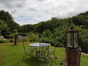 een tafel en stoelen in een tuin met een lamp bij la grange aux oiseaux in Arnaville