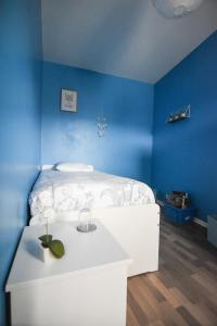 Camera blu con letto bianco e tavolo di Appartement "le Terminus " Gare-Cosy-Wifi 6 Personnes a Saint-Quentin