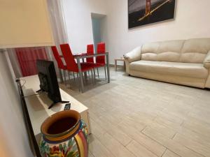 uma sala de estar com um sofá e uma televisão em Casa vacanza La Collegiata em Catânia