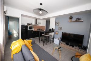een woonkamer met een bank en een televisie bij Explore the World 1 in Perpignan +17 foto's