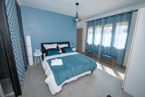 a blue bedroom with a large bed and blue walls at Explore the World 1 in Perpignan