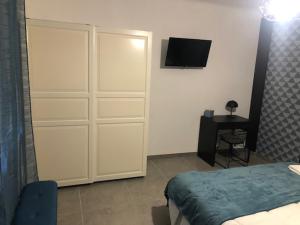 een slaapkamer met een bed en een tv aan de muur bij Explore the World 1 in Perpignan
