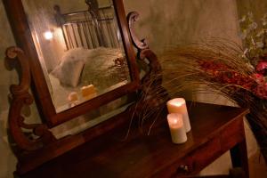 a mirror on a dresser next to a table with a candle at Robur Marsorum Albergo Diffuso in Rocca di Mezzo