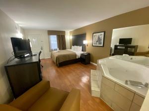 Quality Inn Branson - Hwy 76 Central في برانسون: غرفة في الفندق مع سرير وحوض استحمام