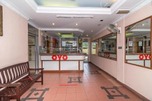 una sala de espera con un banco en una tienda en OYO 89864 Hotel Holiday Park en Kota Kinabalu