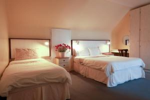 a hotel room with two beds and flowers in it at Arus Grattan in Galway