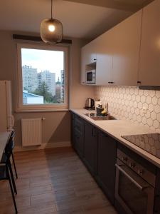 a kitchen with a large window and a counter top at Sun Apartment Katowice Chorzów in Katowice