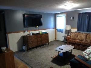 a living room with a couch and a flat screen tv at The Diamond Hideaway in Murfreesboro