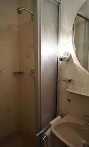 ein Bad mit einer Dusche, einem Waschbecken und einem Spiegel in der Unterkunft Hotel de l' Esplanade in Remich