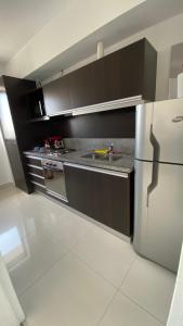 uma cozinha com um frigorífico e um lavatório. em Topacio Tower apartamento de lujo em Buenos Aires