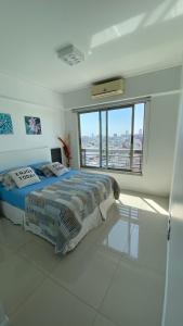 um quarto com uma cama e uma grande janela em Topacio Tower apartamento de lujo em Buenos Aires