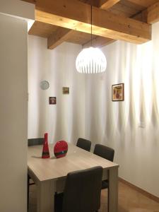 uma mesa de jantar com cadeiras e um item vermelho em Cavallotti em Sassari
