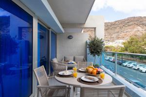 a table with a bowl of fruit on a balcony at Sunny Valley Apartment in Mogán