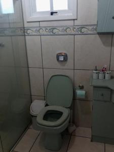 a bathroom with a green toilet and a window at Casa de campo Recanto das Borboletas in Bom Retiro