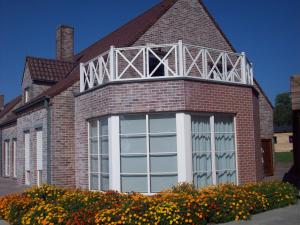 un edificio de ladrillo con una gran ventana en él en B&B Wijnendalvallei en Torhout