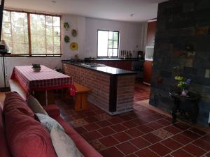 a living room with a couch and a table in a kitchen at CASA PRADA de Ruitoque in Piedecuesta