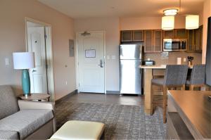 een woonkamer met een keuken met een koelkast bij Staybridge Suites - Orenco Station, an IHG Hotel in Hillsboro