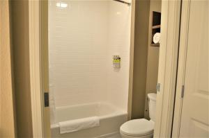 een badkamer met een wit bad en een toilet bij Staybridge Suites - Orenco Station, an IHG Hotel in Hillsboro