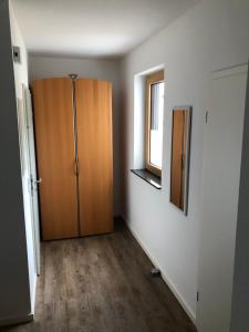 Habitación con armario de madera y ventana. en Ferienappartement Veit en Piesport