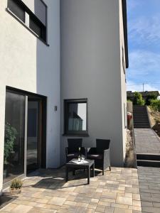 un patio con sillas y una mesa en un edificio en Ferienappartement Veit en Piesport