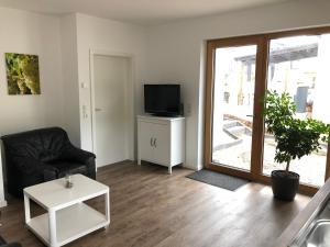 sala de estar con silla negra y TV en Ferienappartement Veit en Piesport