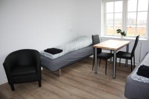 a room with a bed and a table and chairs at Skibbild Bed no Breakfast in Herning