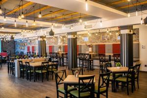 a dining room with tables and chairs and a bar at Milmari MINART S40 in Kopaonik