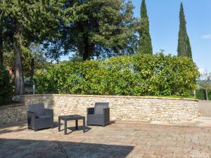 twee stoelen en een tafel voor een stenen muur bij Belvilla by OYO Fienile Sonia in Lucardo