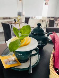 uma mesa preta com um copo e um prato com um limão em KAMIENICA Pokoje & Restauracja em Opalenica