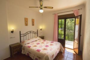 Un dormitorio con una cama y una puerta corrediza de vidrio. en Casas el Albarracín, en El Bosque