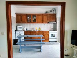 a kitchen with wooden cabinets and a blue bench at O Terraço da Ribeira in Sertã
