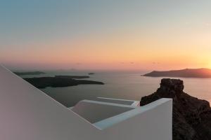 a view of the ocean from a white building at Grace Hotel Santorini, Auberge Resorts Collection in Imerovigli